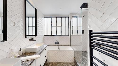 une salle de bain blanche avec une baignoire et un lavabo dans l'établissement 178 Suite Cesar - Superb apartment in Paris, à Paris