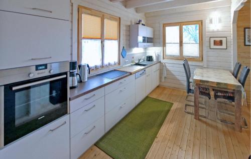 a kitchen with white cabinets and a wooden floor at Ferienhaus Tollenseheim in Krickow