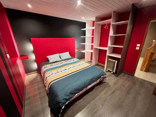 a bedroom with a bed with a red headboard and shelves at Gîte Le Tilleul in Le Tilleul