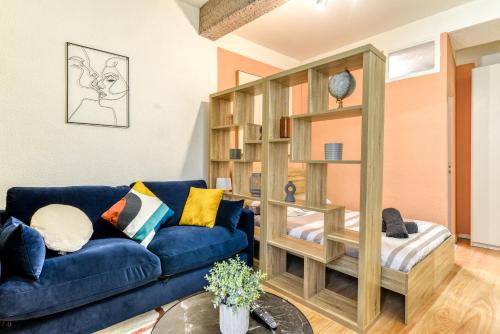 - un salon avec un canapé bleu et une étagère à livres dans l'établissement El Quatro - Wifi - Central - tout équipé, à Carcassonne