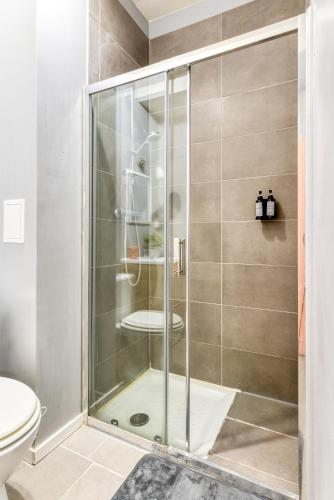 une douche avec une porte vitrée dans une salle de bain dans l'établissement El Quatro - Wifi - Central - tout équipé, à Carcassonne