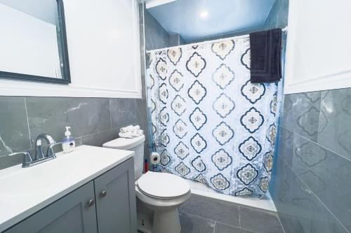 Un baño con inodoro y cortina de ducha. en Comfy 4BR-Free Parking-Wi-Fi in Niagara Falls NY, en Niagara Falls