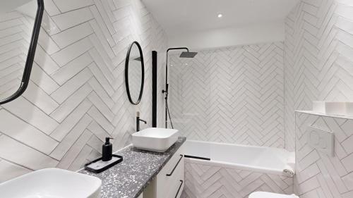 une salle de bain blanche avec un lavabo et un miroir dans l'établissement 169 Suite W - Élégant Appartement à Paris, à Paris