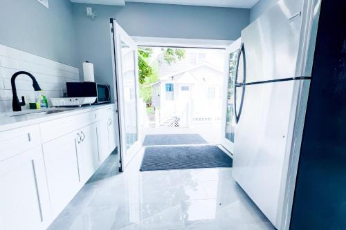 a kitchen with a door open to a patio at 2 Homes, 1 Stay-7BR Niagara Falls Compound in Niagara Falls