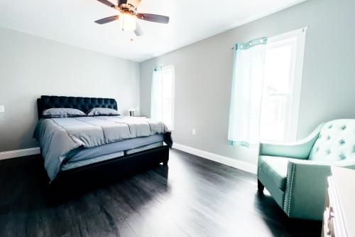 a bedroom with a bed and a couch and a chair at 2 Homes, 1 Stay-7BR Niagara Falls Compound in Niagara Falls