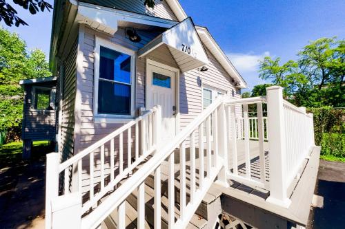 a small white house with a white staircase at 2 Homes, 1 Stay-7BR Niagara Falls Compound in Niagara Falls