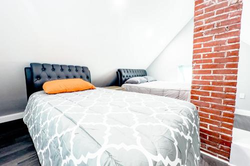 a bedroom with a bed with an orange pillow on it at 2 Homes, 1 Stay-7BR Niagara Falls Compound in Niagara Falls
