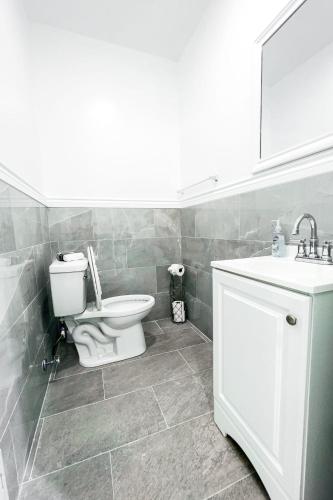 a bathroom with a toilet and a sink at 2 Homes, 1 Stay-7BR Niagara Falls Compound in Niagara Falls