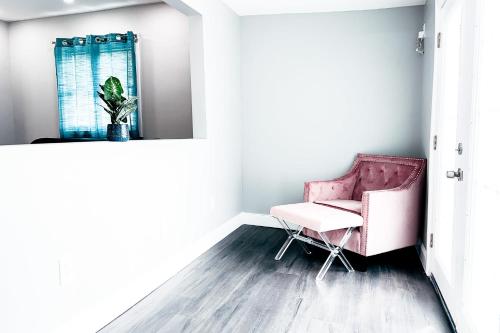 a room with a pink chair and a mirror at 2 Homes, 1 Stay-7BR Niagara Falls Compound in Niagara Falls