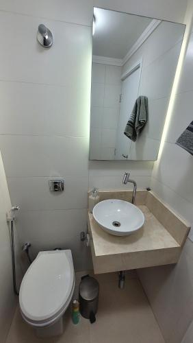 a bathroom with a sink and a toilet and a mirror at Quarto e banheiro privativos no Jardins in São Paulo