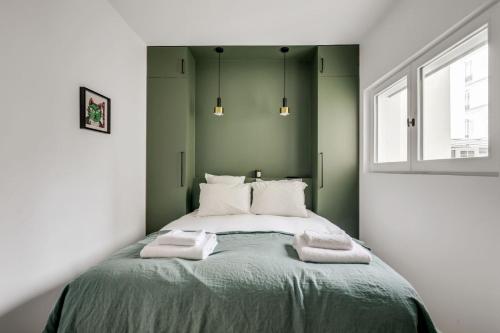 une chambre avec un lit avec deux serviettes dessus dans l'établissement 168 Suite M - Superbe Appartement à Paris, à Paris