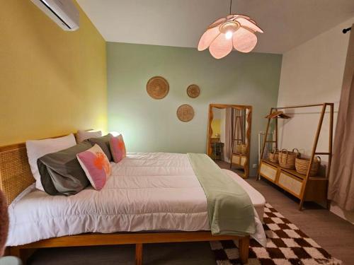 une chambre avec un lit et un ventilateur de plafond dans l'établissement Le Pastel YourHostHelper, à Narbonne