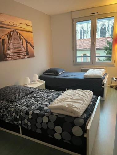 une chambre avec deux lits et un tableau au mur dans l'établissement 115 Rue Vauban, à Lyon