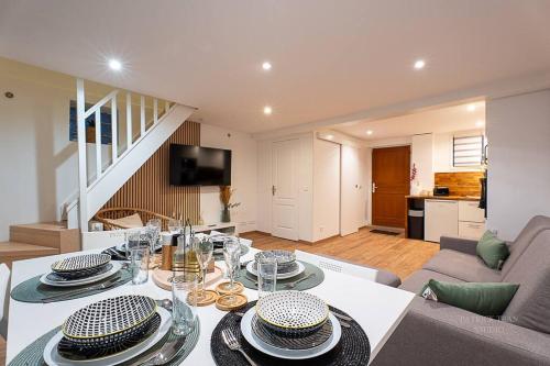 - un salon avec une table et de la vaisselle dans l'établissement Maison avec jardin 8 personnes près de disney & Paris, à Jossigny