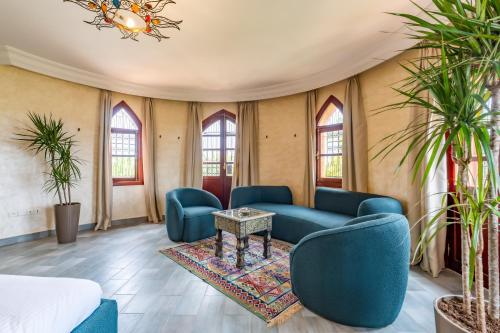 a living room with blue furniture and plants at Château Loriana in Bouznika