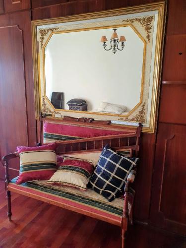 a bench with pillows in front of a mirror at TR House Amadora in Amadora