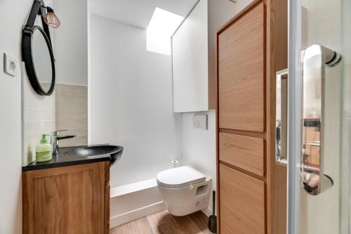 une petite salle de bain avec toilettes et lavabo dans l'établissement 136 Suite Harold - Superbe Appartement à Paris., à Paris