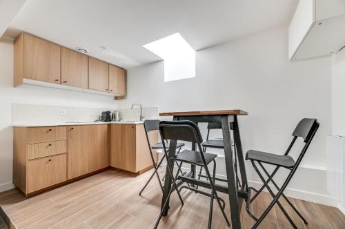 une cuisine avec une table et des chaises dans une pièce dans l'établissement 136 Suite Harold - Superbe Appartement à Paris., à Paris