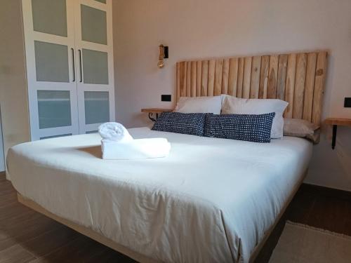 a bedroom with a large white bed with a wooden headboard at Casa María 2 in Barcia