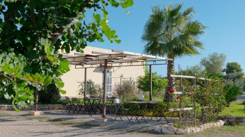 a picnic shelter with tables and chairs in a park at Delle Rose Horses Club in Torre Vado