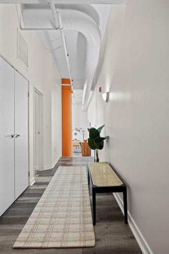 an empty hallway with a bench and orange walls at Indy Urban Nest - Sleeps 8 - Skywalk Access - Convention Center in Indianapolis