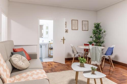 ein Wohnzimmer mit Sofa und Tisch in der Unterkunft 1 parada al Casco Viejo, 1 min en metro - Santutxu in Bilbao