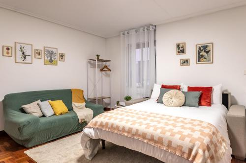 ein Schlafzimmer mit einem Bett und einer Couch in der Unterkunft 1 parada al Casco Viejo, 1 min en metro - Santutxu in Bilbao
