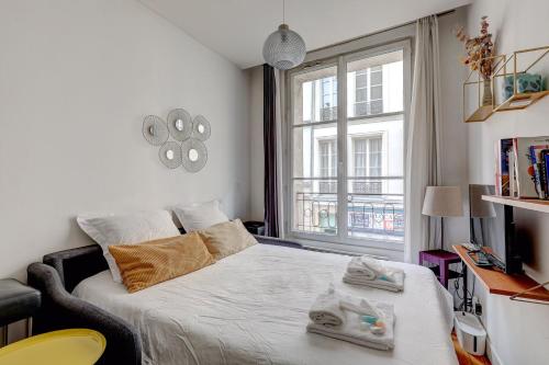 une chambre avec un lit et une grande fenêtre dans l'établissement 310 Suite Petit Nid Douillet Apartment in Paris, à Paris