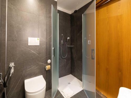a bathroom with a glass shower with a toilet at B&B Hotel Roma Tuscolana San Giovanni in Rome