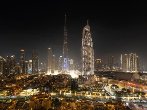 a night view of a large city with tall buildings at SmartStay at Burj Royale - Full Burj Khalifa View - Brand New Luxury Apartments in Dubai