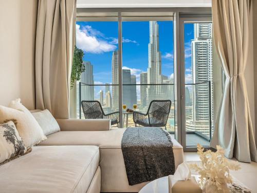 a living room with a couch and a large window at SmartStay at Burj Royale - Full Burj Khalifa View - Brand New Luxury Apartments in Dubai