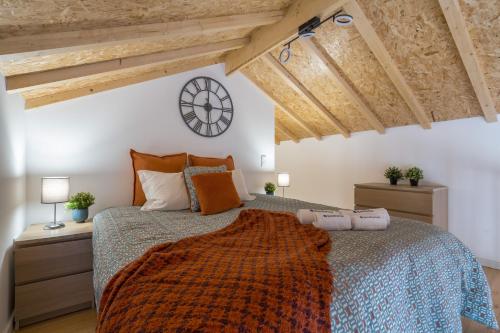 a bedroom with a bed and a clock on the wall at Host Wise - Stylish Duplex House - Terrace & River View in Vila Nova de Gaia