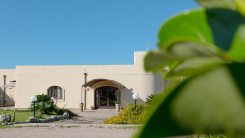 a white building with a door and a yard at Delle Rose Horses Club in Torre Vado