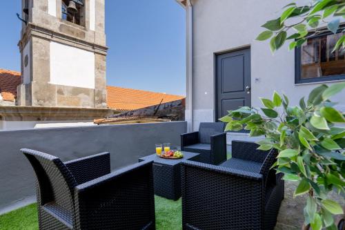 a patio with chairs and a table on a balcony at Host Wise - Stylish Duplex House - Terrace & River View in Vila Nova de Gaia