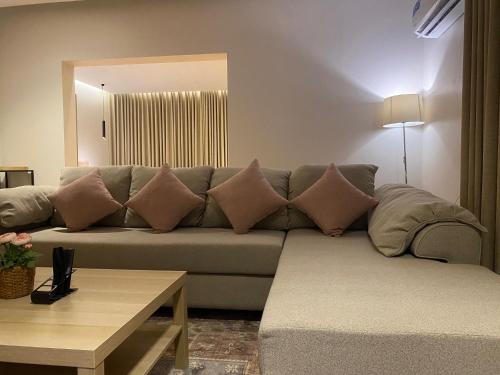 a living room with a couch with pillows on it at دار نوره وحدة سكنية في منتصف جدة in Jeddah