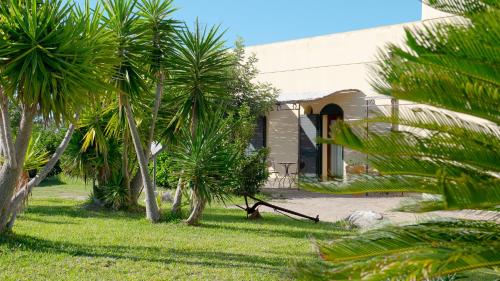 a building with palm trees in front of it at Delle Rose Horses Club in Torre Vado