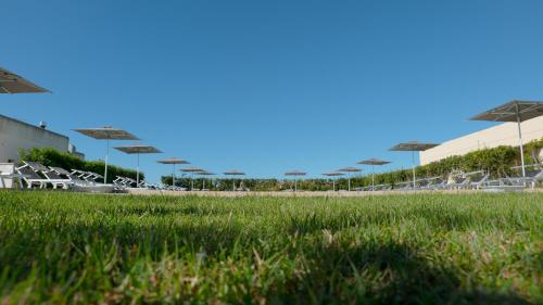a field of green grass with umbrellas in a stadium at Delle Rose Horses Club in Torre Vado