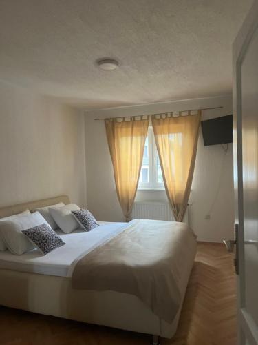 a bedroom with a large white bed with curtains at Hotel Pilot in Cazin