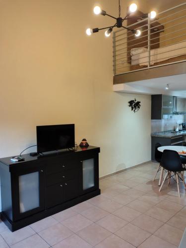 a living room with a flat screen tv on a cabinet at Mono en Duplex Velez Sarsfield 2 in Buenos Aires