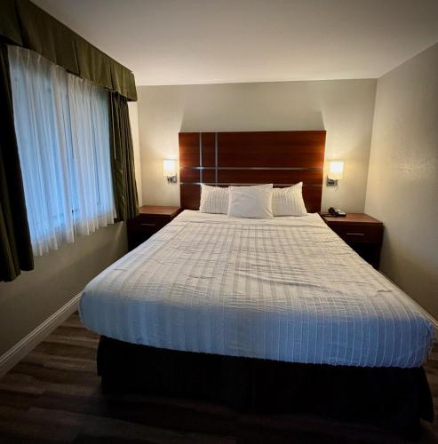 a bedroom with a large bed with a wooden headboard at Western Holiday Lodge in Three Rivers