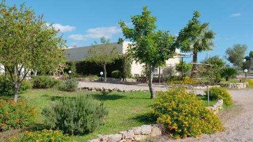 a garden with trees and flowers in front of a building at Delle Rose Horses Club in Torre Vado