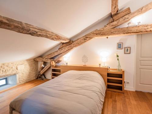a bedroom with a large bed in an attic at Les Ecures 1 in Puy-de-Versac