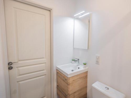 a white bathroom with a sink and a mirror at Les Ecures 1 in Puy-de-Versac