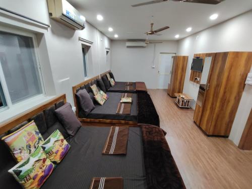 a room with couches and a couch and a tv at Hotel Shree Kedarnath in front of railway station platform no 8 in Ujjain