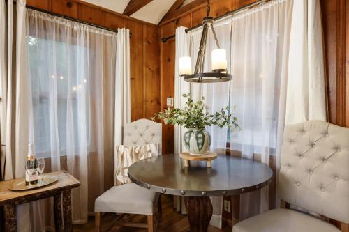 a dining room with a table and chairs and a window at Arrowhead Pine Rose Cabins in Twin Peaks