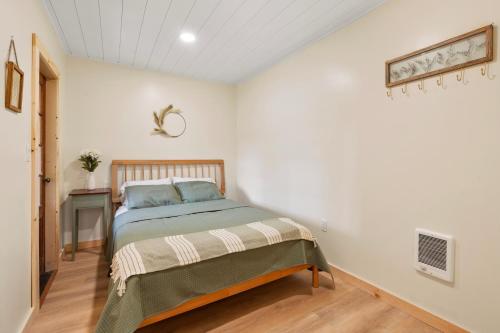 a bedroom with a bed in a white room at Squam Lake 3 bed plus 3 bath rental (Suite 7) in Holderness