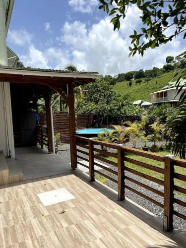 a wooden deck with a wooden fence and a swimming pool at o kalm vert in Morne-à-lʼEau