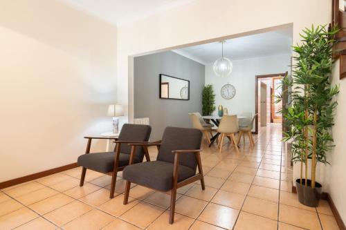 a living room with chairs and a dining room at Host Wise - Spacious Duplex House - Jacuzzi & Terrace in Porto