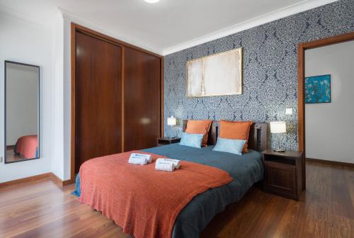 a bedroom with a bed with two towels on it at Host Wise - Spacious Duplex House - Jacuzzi & Terrace in Porto