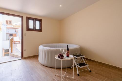 a room with a large tub and a table with a bottle of wine at Host Wise - Spacious Duplex House - Jacuzzi & Terrace in Porto